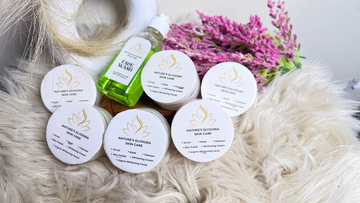 Nature's Elements skin care products on a soft surface with flowers in the background